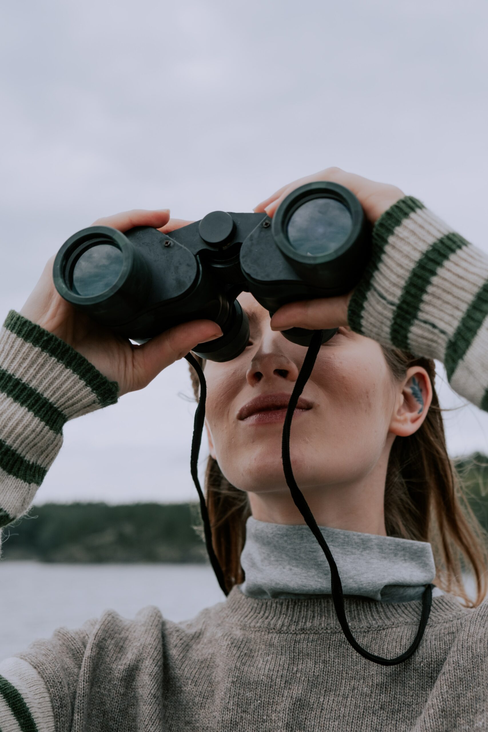 Woman looking through binoculars (Photo by cottonbro from Pexels)