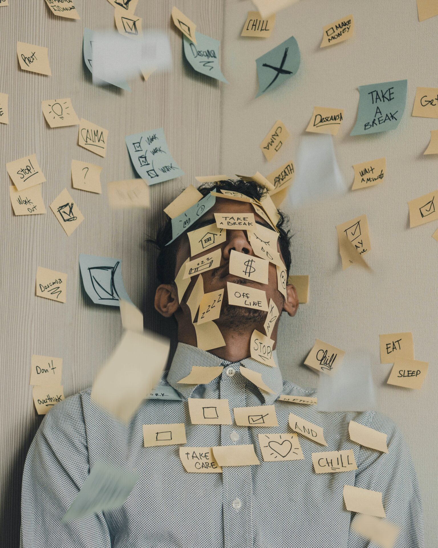 Man with face and chest covered in sticky notes (Photo by Luis Villasmil on Unsplash)