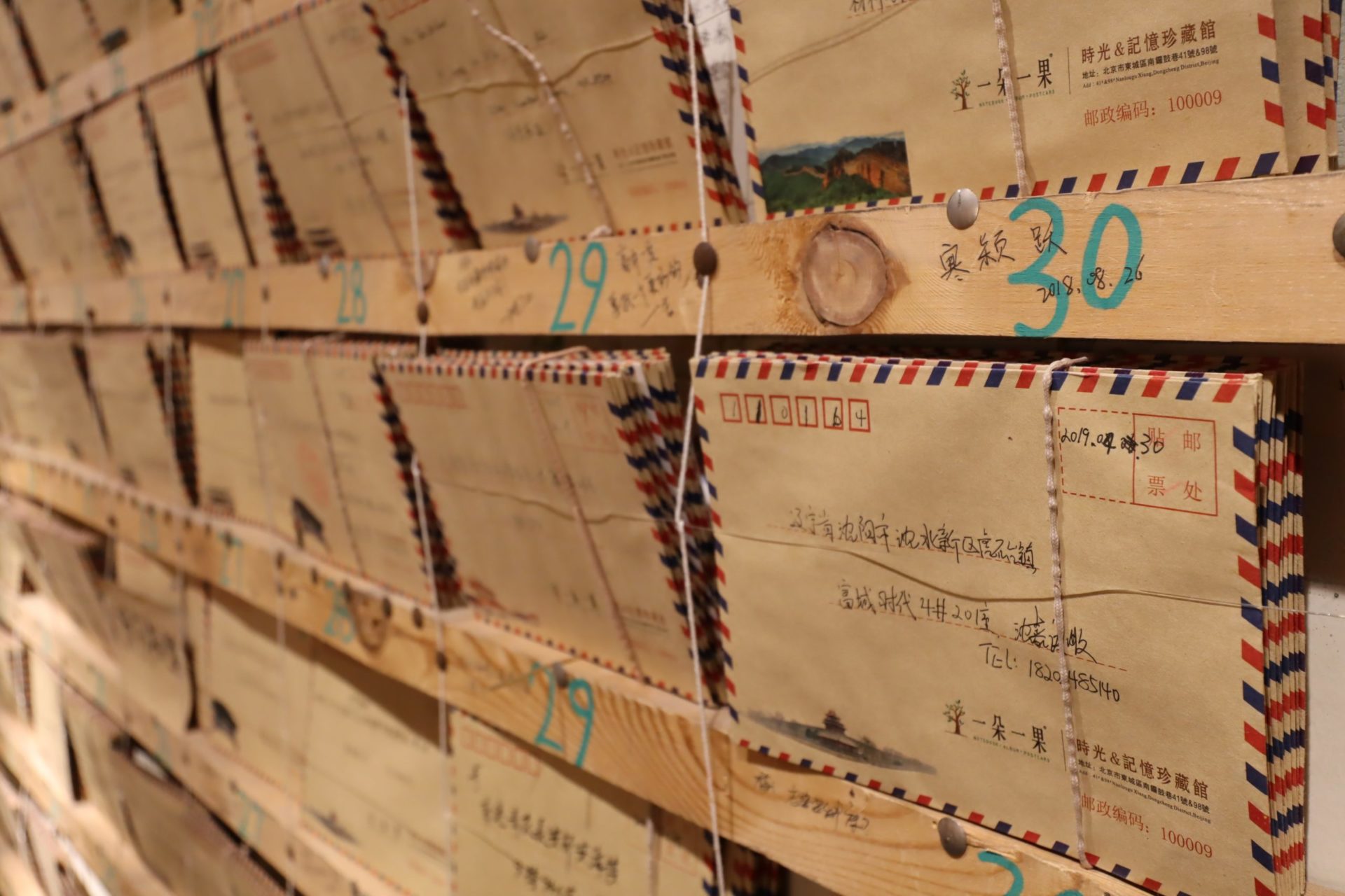 Bundles of Chinese airmail letters on wooden shelves (Photo by Carol Jeng on Unsplash)