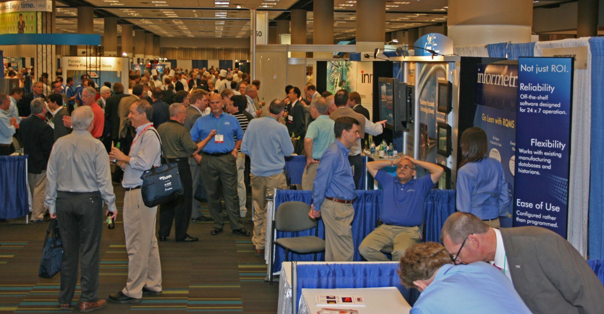A crowd of men networking at PaperCon 2010