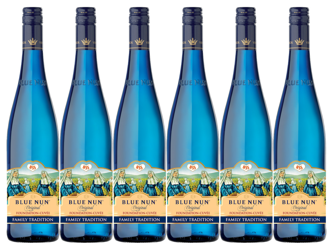 Six bottles of Blue Nun wine stand in a row against a white background