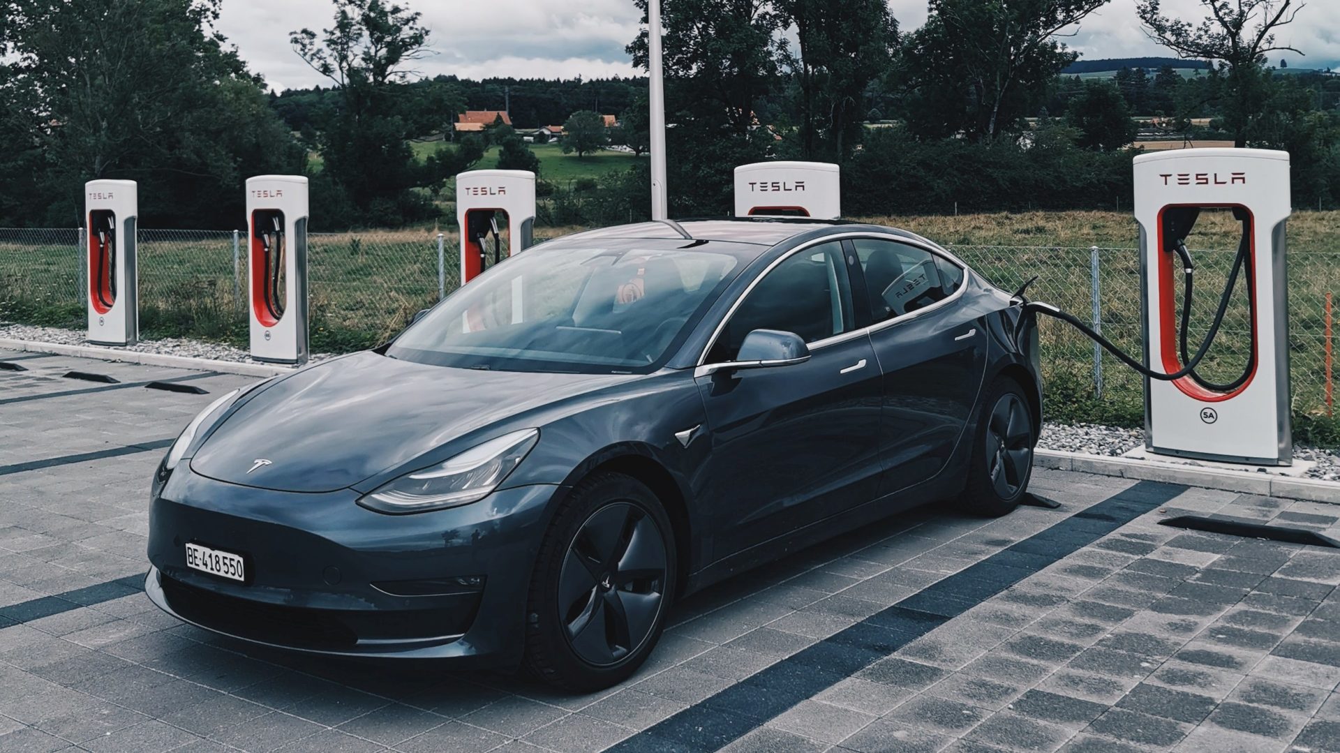 Tesla charging at a Supercharger station (Photo by Dario on Unsplash)