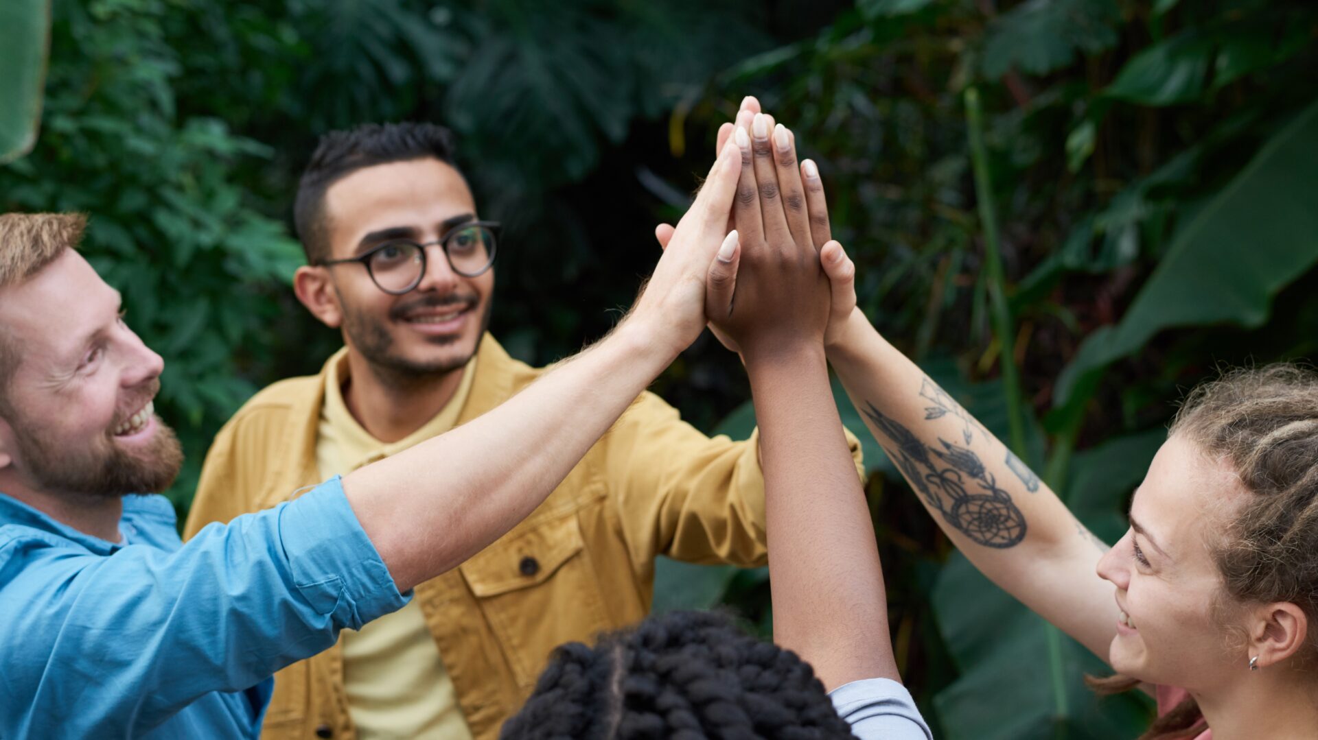 People doing an awkward group high five (Photo by fauxels on Pexels)